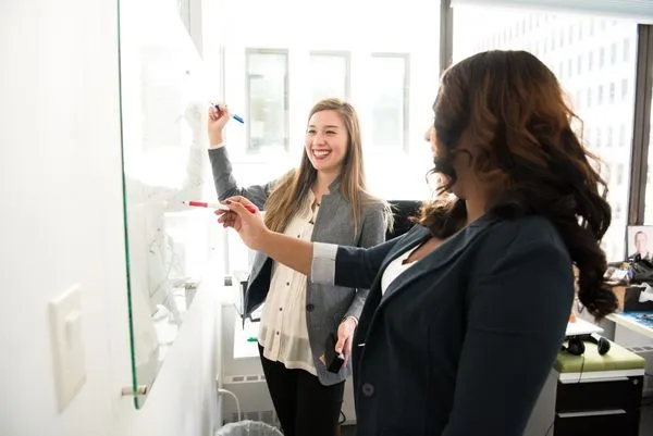 Two women at a whiteboard